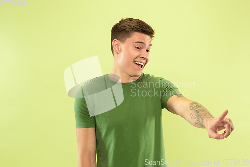 Image of Caucasian young man\'s half-length portrait on green background