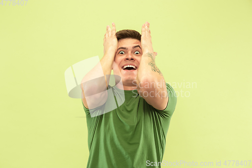 Image of Caucasian young man\'s half-length portrait on green background