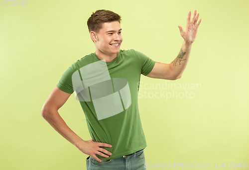 Image of Caucasian young man\'s half-length portrait on green background