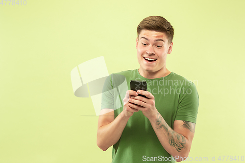 Image of Caucasian young man\'s half-length portrait on green background