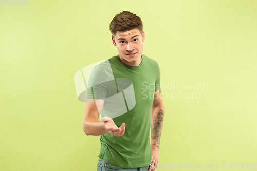 Image of Caucasian young man\'s half-length portrait on green background