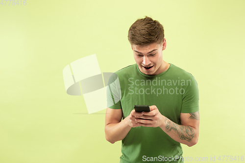 Image of Caucasian young man\'s half-length portrait on green background