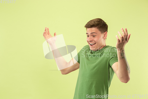 Image of Caucasian young man\'s half-length portrait on green background
