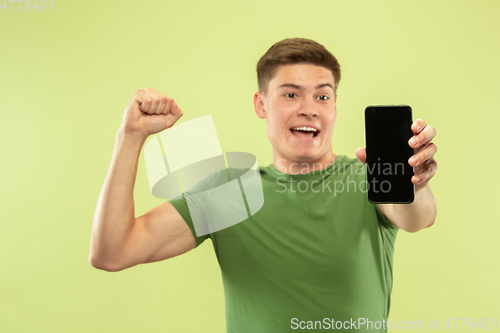 Image of Caucasian young man\'s half-length portrait on green background