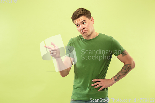 Image of Caucasian young man\'s half-length portrait on green background
