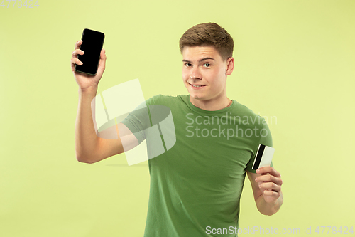 Image of Caucasian young man\'s half-length portrait on green background