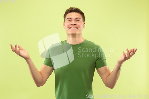 Image of Caucasian young man\'s half-length portrait on green background