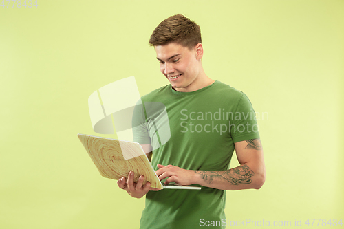 Image of Caucasian young man\'s half-length portrait on green background