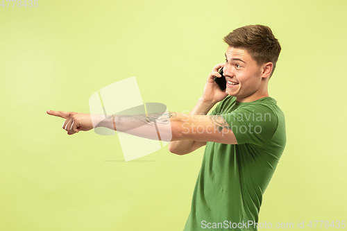 Image of Caucasian young man\'s half-length portrait on green background