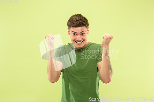 Image of Caucasian young man\'s half-length portrait on green background