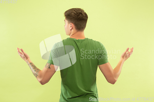 Image of Caucasian young man\'s half-length portrait on green background