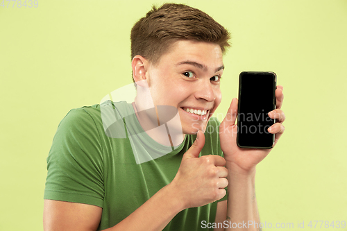 Image of Caucasian young man\'s half-length portrait on green background