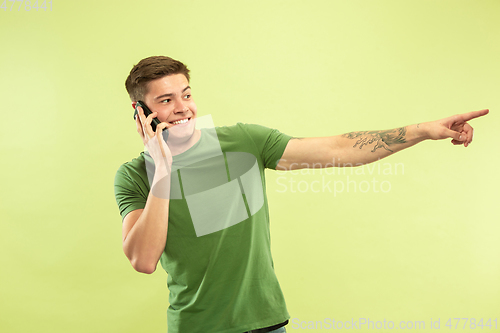 Image of Caucasian young man\'s half-length portrait on green background