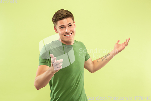 Image of Caucasian young man\'s half-length portrait on green background