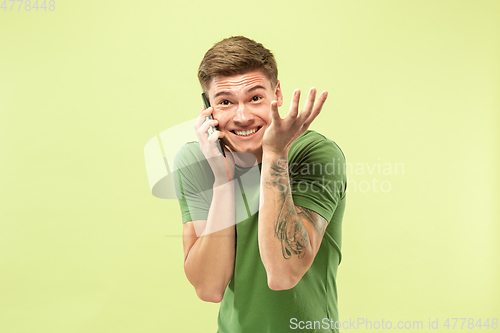 Image of Caucasian young man\'s half-length portrait on green background