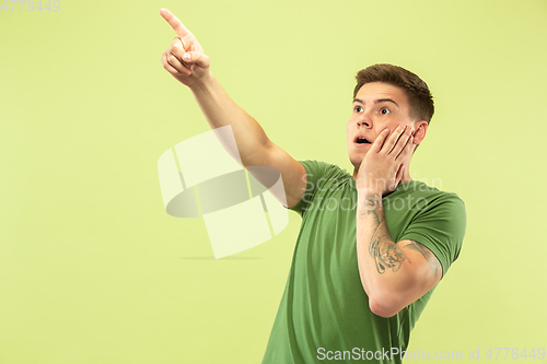 Image of Caucasian young man\'s half-length portrait on green background
