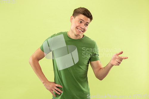 Image of Caucasian young man\'s half-length portrait on green background