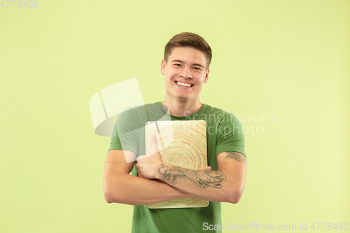 Image of Caucasian young man\'s half-length portrait on green background