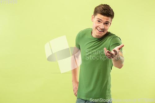 Image of Caucasian young man\'s half-length portrait on green background