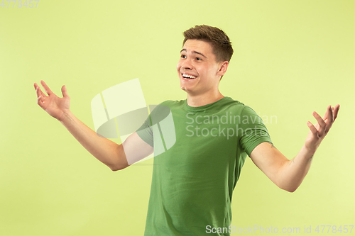 Image of Caucasian young man\'s half-length portrait on green background