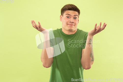 Image of Caucasian young man\'s half-length portrait on green background