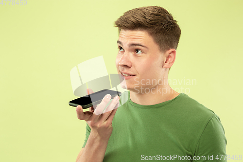 Image of Caucasian young man\'s half-length portrait on green background