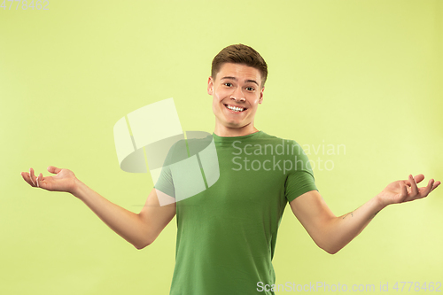 Image of Caucasian young man\'s half-length portrait on green background