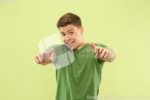 Image of Caucasian young man\'s half-length portrait on green background
