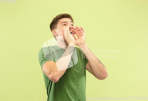 Image of Caucasian young man\'s half-length portrait on green background