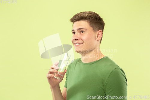 Image of Caucasian young man\'s half-length portrait on green background