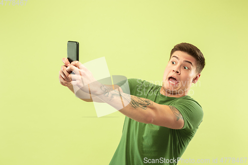 Image of Caucasian young man\'s half-length portrait on green background