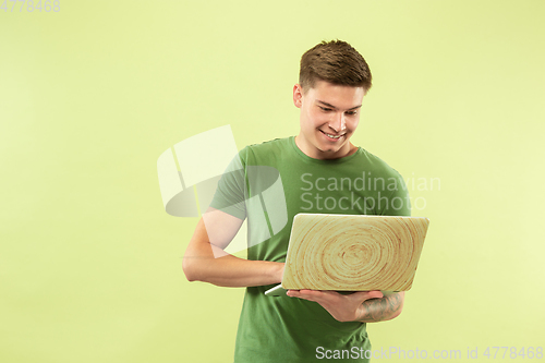 Image of Caucasian young man\'s half-length portrait on green background