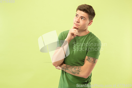 Image of Caucasian young man\'s half-length portrait on green background