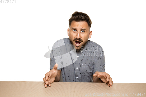 Image of Shocked and upset man opening the biggest postal package