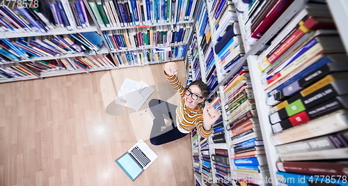 Image of the student uses a notebook and a school library