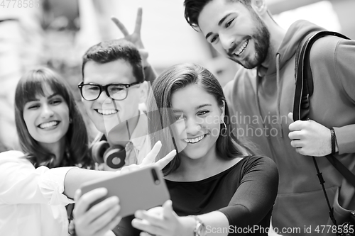 Image of Group of multiethnic teenagers taking a selfie in school