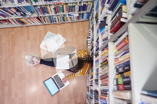 Image of the student uses a notebook and a school library