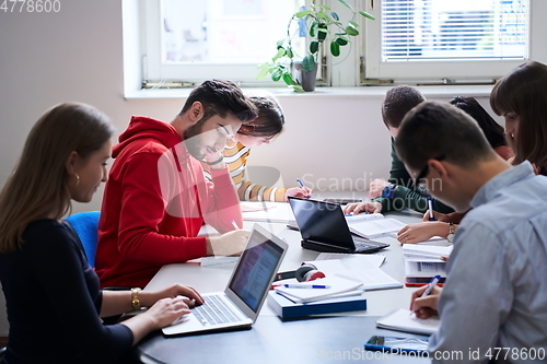 Image of students group working on school project together on tablet computer at modern university