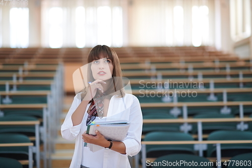 Image of famale student using pen and notebook