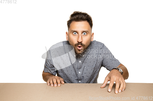 Image of Shocked man opening the biggest postal package