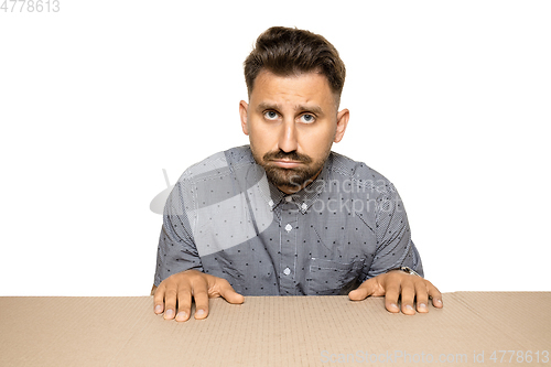 Image of Shocked and upset man opening the biggest postal package