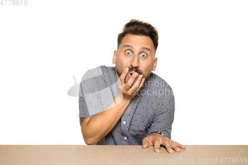 Image of Shocked man opening the biggest postal package