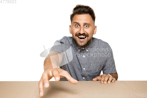 Image of Shocked man opening the biggest postal package