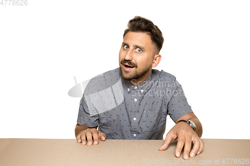 Image of Shocked man opening the biggest postal package