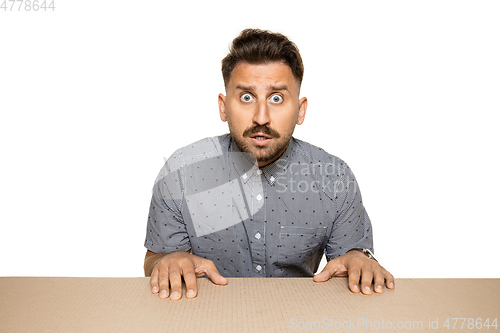 Image of Shocked man opening the biggest postal package