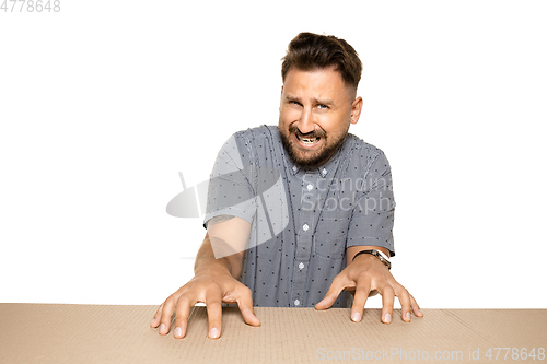 Image of Shocked and upset man opening the biggest postal package