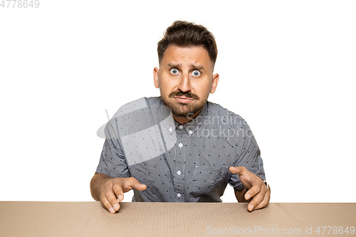 Image of Shocked and upset man opening the biggest postal package