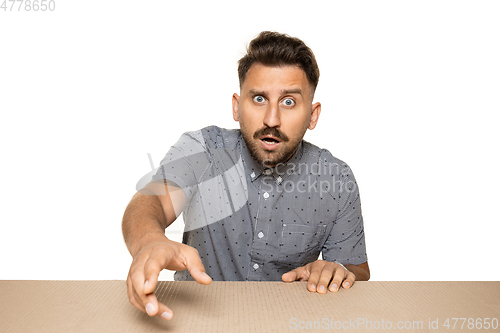 Image of Shocked man opening the biggest postal package