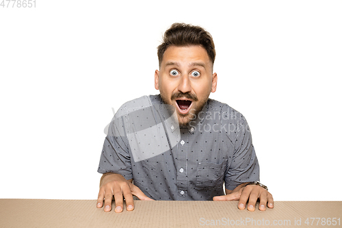 Image of Shocked man opening the biggest postal package