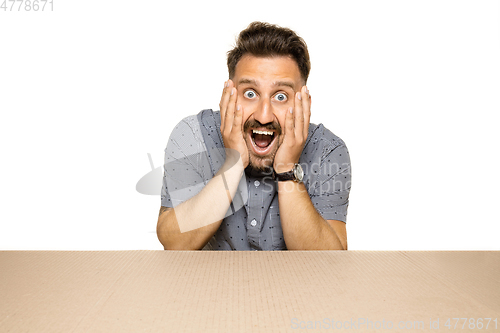 Image of Shocked man opening the biggest postal package